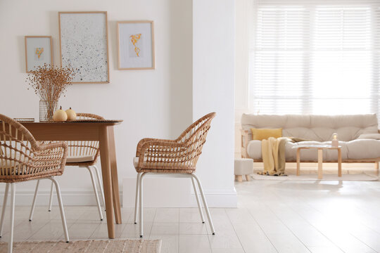 Dining room interior with wooden table and wicker chairs