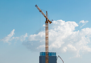 Obraz premium A huge crane way up in the air is working on a skyscraper in downtown Los Angeles.