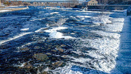 Water rushes down the fox river in winter