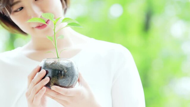 植物を持つ女性　環境保護イメージ　スローモーション