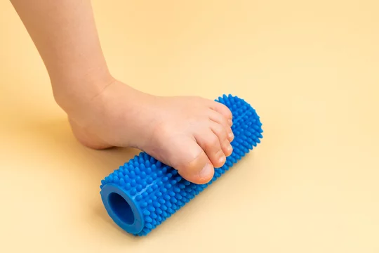 blue needle roller for massage and on beige background with the image of a foot, the concept of prevention and treatment of hallux valgus Stock-foto | Adobe Stock