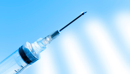 Closeup of a syringe on blue background
