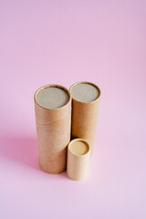 Craft tubes of different sizes stand on a pink background. Cardboard boxes for pencils. Packing set. subject survey of packaging goods