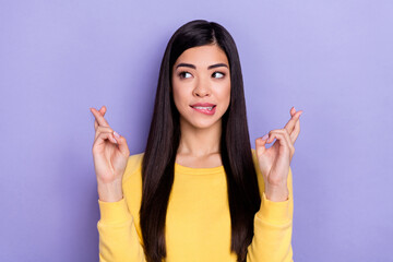 Photo of young pretty woman worried bite lips pleading luck pray look empty space isolated over...