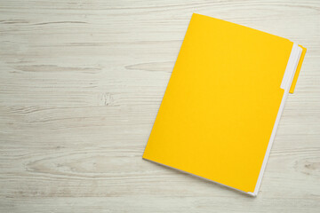 Yellow file with documents on white wooden table, top view. Space for text