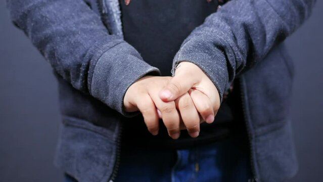 a nervous child girl's hand isolated on black 