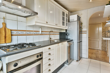 Small kitchen with white tiles on the wall