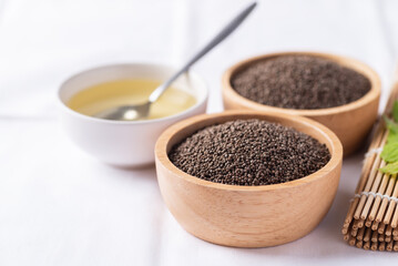 Perilla oil and seeds in bowl on white background, Healthy herbal seed ingredients in Asian food