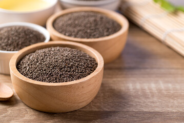Perilla seeds and oil in bowl on wooden table, Healthy herbal seed ingredients in Asian food