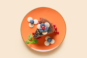 Plate with delicious piece of chocolate cake and berries on light background