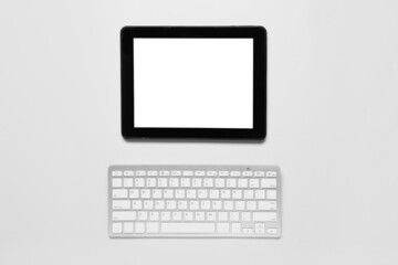 Modern tablet computer and keyboard on white background