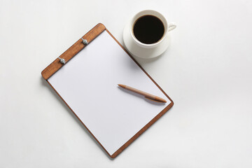 Clipboard with blank sheet of paper, pen and cup of coffee on white background