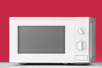 Modern microwave oven on color background