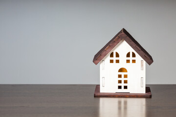Model House On Grey Background With Copy Space. Concept of buying, mortgage, rent and insurance.