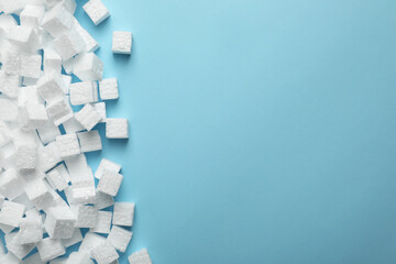 Many styrofoam cubes on light blue background, flat lay. Space for text