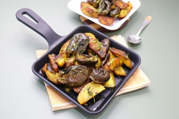 Baingan masala. Indian Potato and aubergine curry. Homemade Indian spicy eggplant and potato curry served in a white plate. Copy space.