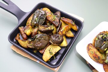 Baingan masala. Indian Potato and aubergine curry. Homemade Indian spicy eggplant and potato curry served in a white plate. Copy space.