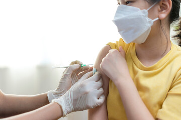 Close up of Young asian girl getting vaccinated or inoculation or Coronavirus Vaccine Injection.