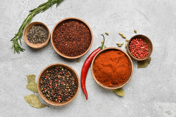 Bowls of aromatic spices on light background
