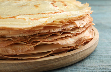 Stack of delicious crepes on blue wooden table, closeup