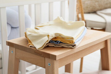 Fototapeta na wymiar Baby clothes on stepladder stool in children's room, closeup