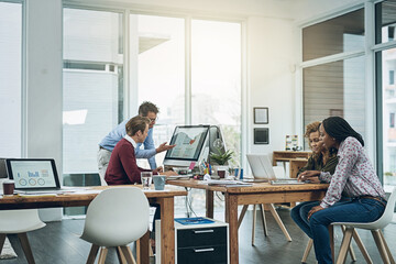 The talent behind a growing startup. Shot of a group of colleagues working together at their desks in a modern office.