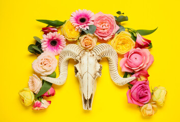 Obraz na płótnie Canvas Skull of sheep with flowers on color background