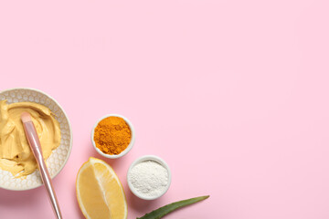 Bowl with turmeric mask, powder, lemon and aloe on pink background