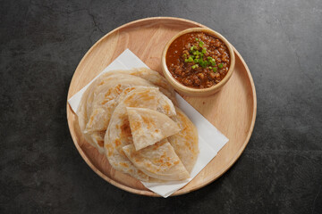 Roti with pork sauce in a wooden cup Indian style food
