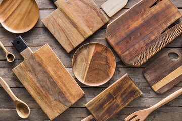 Different cutting boards and plates on wooden background