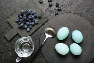 Natural dyed Easter eggs and spoon on dark background