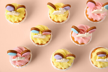 Tasty Easter cupcakes on pink background