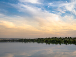 Fototapeta na wymiar Sunset on a red, blue sky near a river or lake.