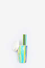 Take away colored paper coffee cup with plastic cap and paper drinking straws. Bright colors and summer drink concept.