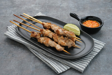 Sate Taichan, Grilled Chicken Satay without peanut sauce or soy sauce. Served on plate with sambal (chilli sauce). Selected focus.
