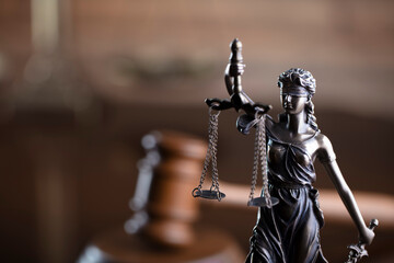Fototapeta na wymiar Law concept. Law symbols composition: judge’s gavel, Themis sculpture and scale on the brown background.