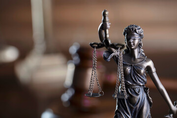 Law concept. Law symbols composition: judge’s gavel, Themis sculpture and scale on the brown background.