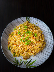 steamed veg rice in bone china white plate with black background from top angle