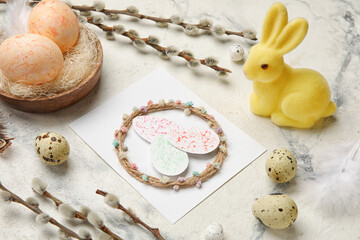 Beautiful Easter composition with greeting card, eggs, bunny and pussy willow branches on light background, closeup