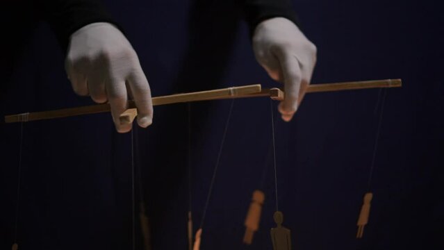 Conspiracy theory concept. People - puppet dolls marionette controlled from above using wires or strings in the hands of the puppeteer