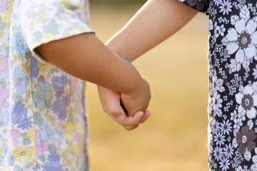 Close up focus on the hands of two little boy holding hands at outdoor.