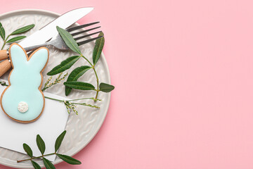 Stylish table setting with Easter cookie on pink background