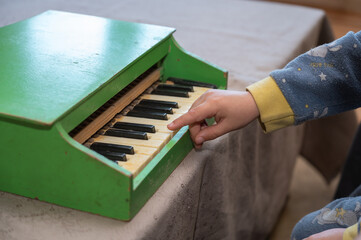 A boy playing a toy piano.