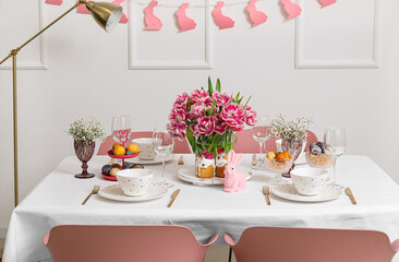 Stylish table setting with beautiful tulips for Easter celebration in room