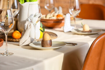 Plate with egg and eucalyptus branch on table served for Easter celebration