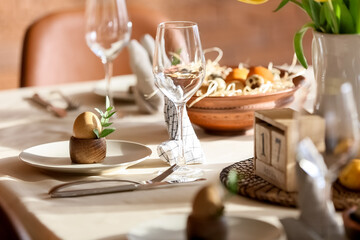 Plate with egg and eucalyptus branch on table served for Easter celebration