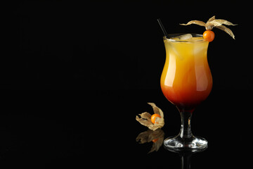 Tasty cocktail decorated with physalis fruit on black background. Space for text