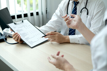 The male doctor sat and checked the patient's history and listened to the patient to clarify the...