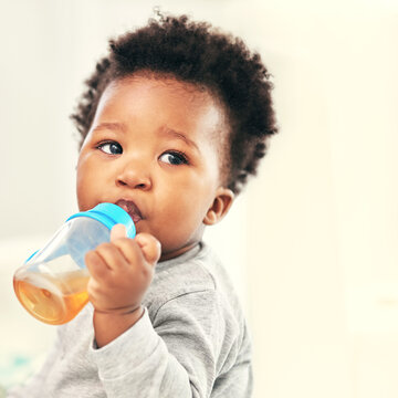 I love my sippy cup. Shot of a little baby boy drinking froma sippy cup at home.