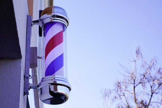 barber pole shop brand sign in wall facade hairdresser in chrome white red blue colors